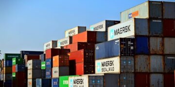 Colorful stacked shipping containers at a port exemplify global logistics.